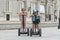 Young happy tourist couple riding segway enjoying city tour in Madrid palace in Spain having fun driving together