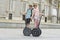 Young happy tourist couple riding segway enjoying city tour in Madrid palace in Spain having fun driving together