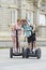 Young happy tourist couple riding segway enjoying city tour in Madrid palace in Spain having fun driving together