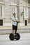 Young happy tourist man riding city tour segway driving happy and excited visiting Madrid palace