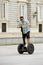 Young happy tourist man riding city tour segway driving happy and excited visiting Madrid palace