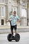 Young happy tourist man riding city tour segway driving happy and excited visiting Madrid palace