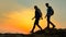 Young Happy Travelers Hiking with Backpacks on the Rocky Trail at Summer Sunset. Family Travel and Adventure Concept.