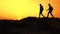 Young Happy Travelers Hiking with Backpacks on the Rocky Trail at Summer Sunset. Family Travel and Adventure Concept.