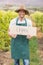 Young happy vintner holding an sign