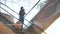 Young happy woman with bags talking on the phone while standing on the escalator at the mall.