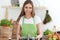 Young happy woman cooking soup in the kitchen. Healthy meal, lifestyle and culinary concept. Smiling student girl