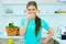 Young happy woman drink water standing in kitchen