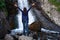 Young happy woman enjoing the summer waterfall