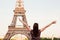 Young happy woman facing the Eiffel Tower, Paris, France