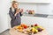 Young Happy Woman holding honey Enjoying While cooking healthy food In Kitchen. Detox Diet, Weight Loss Nutrition