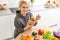 Young Happy Woman holding honey Enjoying While cooking healthy food In Kitchen. Detox Diet, Weight Loss Nutrition