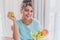 Young Happy Woman Refreshing with Cup of Coffee, Snacks and Fresh Fruit at the Kitchen Table in the Early Morning.