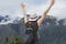 Young happy woman rise hads up in Machu Picchu mountain. Free solo female tourist in hat back view with copy space