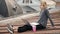 Young happy woman sits with coffee on the rooftop. Wind blowing her hair.