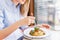 Young happy woman sitting at the table in cafe and enjoying the meal. Hungry woman eating tasty pasta. Dish of spaghetti