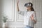 Young happy woman in virtual reality headset enjoying fun shopping experience in augmented world