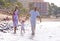 Young, healthy family walking along a sunny beach