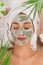 Young healthy woman with face clay mask.