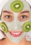 Young healthy woman with face clay mask.