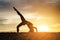 Young healthy woman practicing yoga on the beach exercise at sunset time