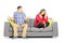 Young heterosexual couple sitting on a couch during an argument