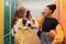 Young high school students meeting and greeting near locker in campus hallway talking and high fiving.