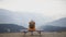 Young hiker at amazing hazy background of mountain landscape in smoke. Happy asian woman tourist sitting on lonely bench