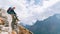 Young hiker backpacker female sitting on cliff edge and enjoying the Imja Khola valley during high altitude Everest Base Camp EBC