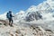 Young hiker backpacker female taking brake in hike walking enjoying Khumbu Glacier. High altitude Everest Base Camp route near