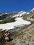 A young hiker collecting some fresh water from the snowmelt from