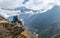 Young hiker female backpacker sitting on the cliff edge and enjoying Ama Dablam 6,812m peak view during Everest Base Camp EBC