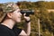 young hiker girl, observing the view from the top of the mountain with her binoculars. concept of hobby and travel.