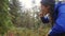 Young hiker girl picking and eating blueberries in autumn forest. 4k slowmotion