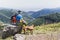 A young hiker and his Vizsla dog hiking to the top of a mountain