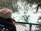 A young hiker looking down admiring the beautiful view of a frozen waterfall at Wapta Falls with the Rocky Mountains