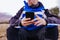 young hiker man using smart phone on top of the mountain. cloudy day