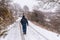 Young hiker with photography tools walking on the snowy road of Mount Aizkorri in Gipuzkoa