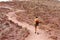 Young hiker woman climbing mountain with red ground in Tenerife