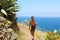 Young hiker woman walking on a trail overlooking the sea in Tenerife