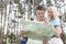 Young hiking couple reading map in forest