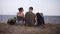 Young hiking couple resting on a hill. Young woman and man hiker take off backpacks sitting on the ground enjoying the