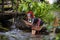 A young hill tribe woman is playing in the water on the waterfall