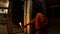 Young hindu monk does repeated movements with burning light fixture in front of enterance in temple night aarti dark evening
