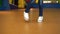 Young hip-hop female dancer in the dancing hall. Close-up shot of dancing feet in white sneakers