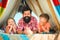 Young hipster bearded dad play with his children at colorful playhouse at the roof. Father have fun with his cute