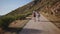 Young hipster couple hikes on mountain road on sunset