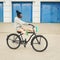 Young hipster girl with black bike