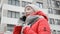 Young hipster girl in a red jacket and knitted hat talking on the phone