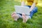 Young hipster girls feet with laptop in a park